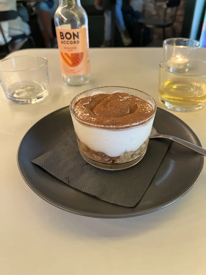 Plantbased tiramisu in a glass with a Bon Accord ginger soda behind